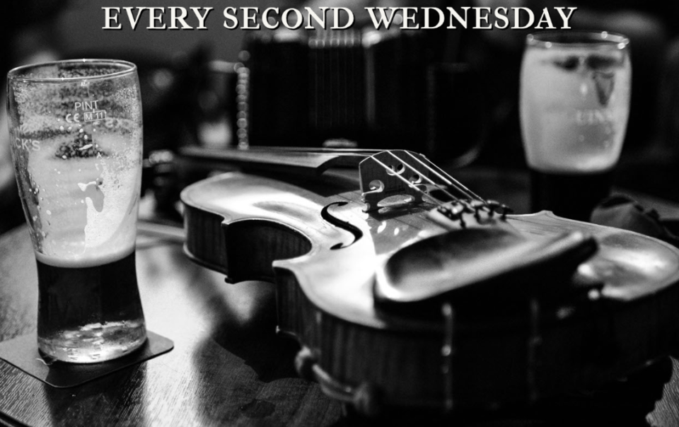 black and white photo of a fiddle and some half-drunk pints of Guinness